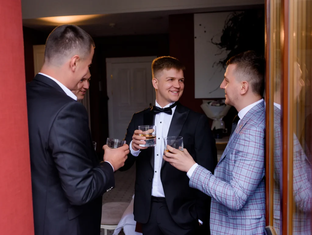 Amis du futur marié partageant un verre et célébrant un enterrement de vie de garçon convivial à Deauville.