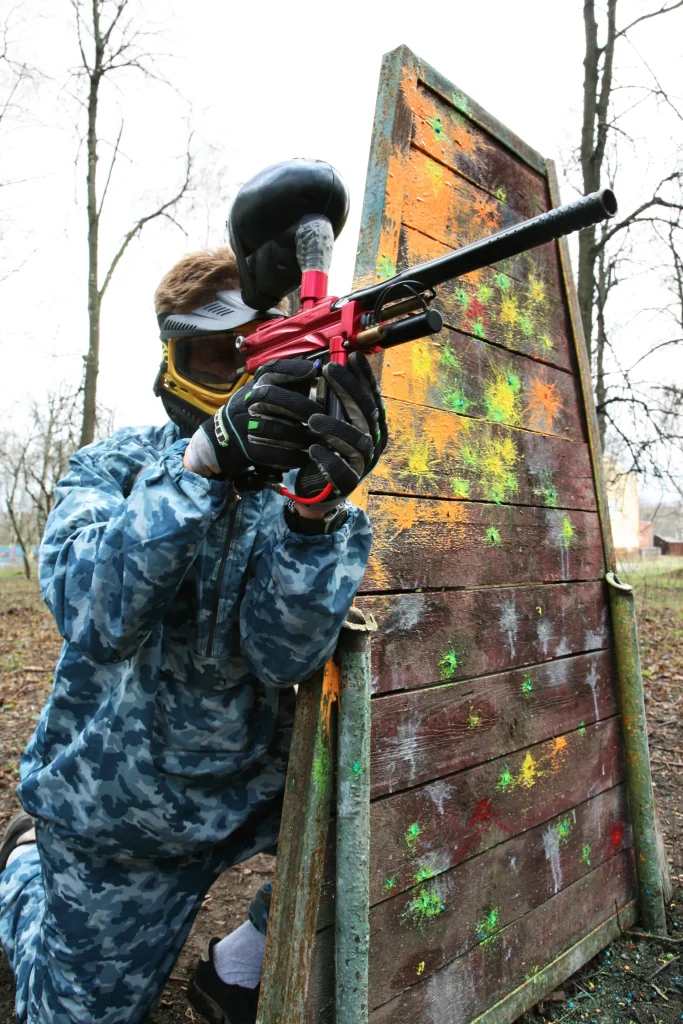 Joueurs alignés avec leur équipement et fusils de paintball, illustrant comment bien viser au paintball grâce à la concentration et au tir coordonné.